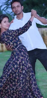 Elegant couple dancing in nature, displaying grace and movement in a serene setting.