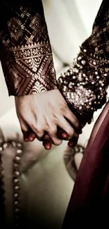 A couple holds hands wearing intricate, traditional attire.