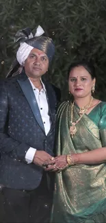 Couple in traditional attire posing elegantly for a portrait.