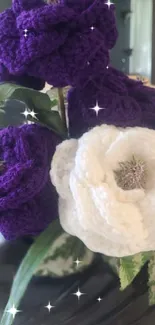 Purple and white crocheted flowers with leaves.