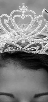 Black and white image of a crown being placed gracefully on a head.