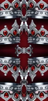 Silver crowns with red jewels on red background.
