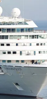 Elegant white cruise ship sailing on serene blue ocean.