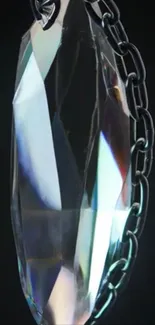 Elegant crystal pendant with chain on dark background.