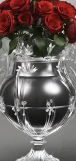 Crystal vase with red roses on a gray background.