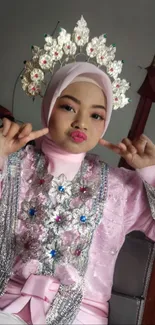 Woman in a pink traditional dress with intricate headpiece.