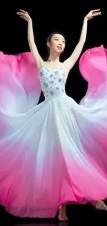 Elegant dancer in a flowing pink and white dress against a black background.