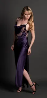 Elegant woman in dark purple satin dress with gold embroidery against dark background.