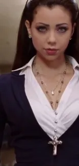 Elegant woman in dark blue attire with cross necklace.