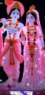 Pink adorned deities with floral garlands.