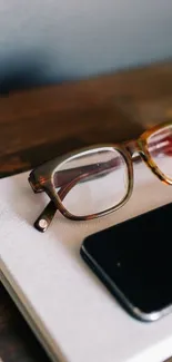 Elegant glasses and smartphone on a wooden desk wallpaper.