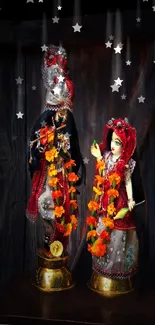 Radha Krishna statues adorned with garlands and vibrant colors on a dark background.