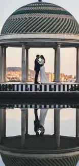 Romantic couple under dome reflected in water.