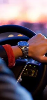 Elegant driving scene with sunset view and stylish watch on steering wheel.