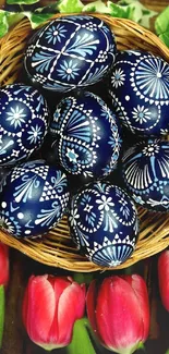 Wicker basket of intricately designed Easter eggs with bright tulips.