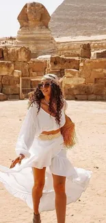 Woman in white dress near Egyptian pyramid and Sphinx.