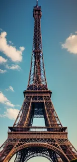 Eiffel Tower against blue sky with clouds.