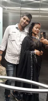 Couple in elegant attire in elevator mirror.