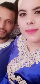 Couple in elegant royal blue attire with intricate embroidery.