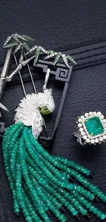 Emerald green jewelry artwork on a textured dark background.