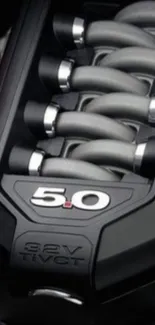 Close-up of a sleek 5.0 engine design in black and metallic tones.