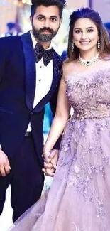 Elegant couple in evening attire, holding hands.