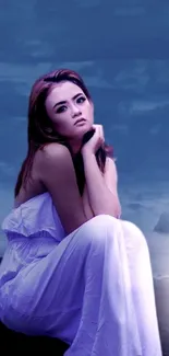 Woman in a white dress sitting thoughtfully against a deep blue night background.