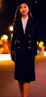 Elegant woman in black coat with city bokeh lights at night.