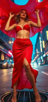Woman in red dress poses gracefully in an urban night scene with city lights.