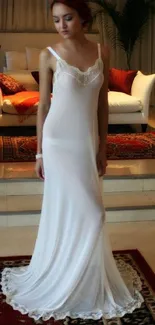 Woman in white dress standing in elegant interior setting.