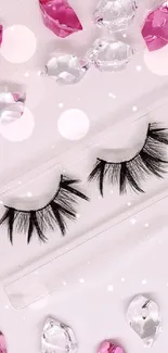 False eyelashes surrounded by pink and clear gems on a white background.