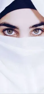 A close-up of expressive eyes framed by a white veil.