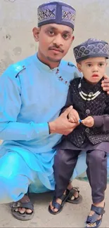 Father and son in traditional attire pose for a portrait.