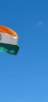 Indian flag gracefully waving in a bright blue sky.