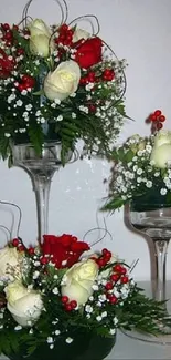 Elegant arrangement with roses and ferns in glass vases.