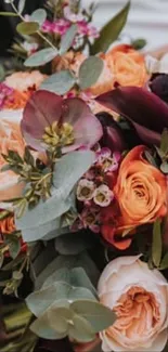 Elegant bouquet of roses and greenery in soft peach and purple hues.