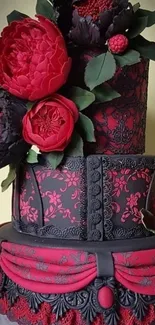 Elegant floral cake with red blooms and black lace design.