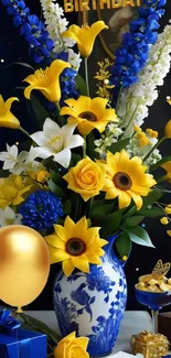 Elegant birthday floral arrangement with yellow and blue flowers, gold balloon, and gifts.