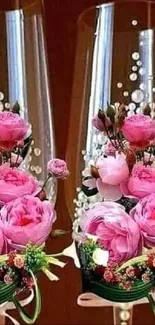 Two champagne glasses with pink roses and pearl decorations.