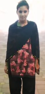 Woman in a floral dress standing outdoors, exuding elegance and style.