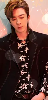 Fashionable individual in black floral outfit against a peach backdrop.