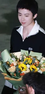 Person holding a colorful floral bouquet in a soft setting.