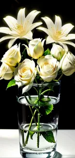 White lilies and roses in a glass vase on a dark background.