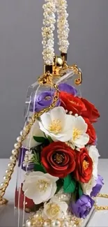 Elegant handbag with floral design and pearl handle on gray background.