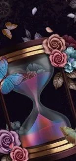 Hourglass with roses and butterflies on a dark background.