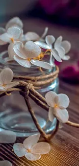 Elegant white flowers in a rustic jar against a brown background.