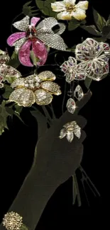 Hand holding jewel-encrusted floral bouquet on black background.