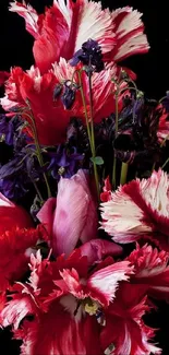 Elegant bouquet of red and pink flowers on a black background.