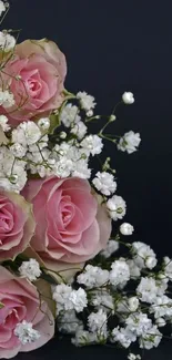 Elegant bouquet of pink roses and white flowers on dark background.