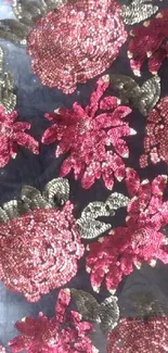 Elegant pink floral embroidery with leafy details on a dark background.